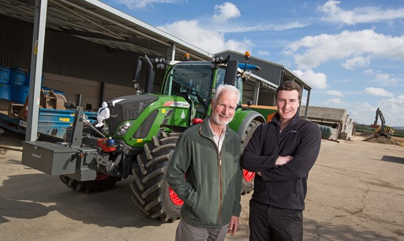 a couple of men standing in front of a tractor